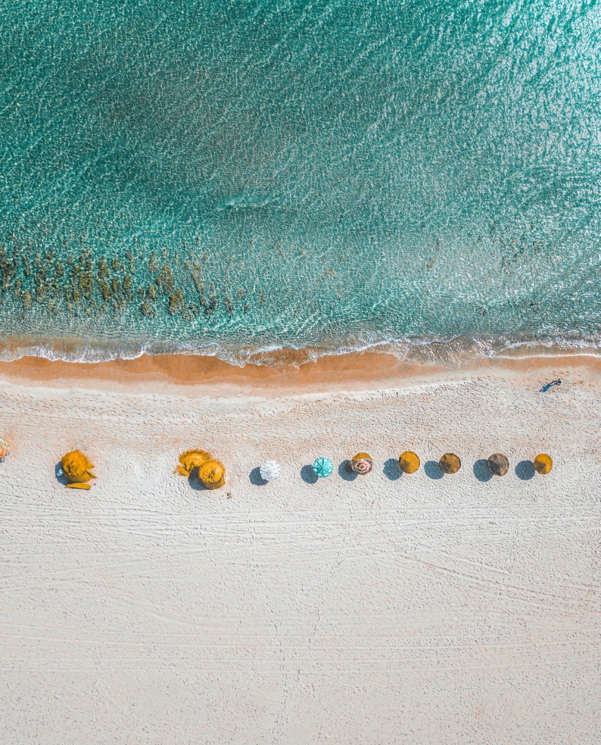 海の浜辺とパラソルの写真